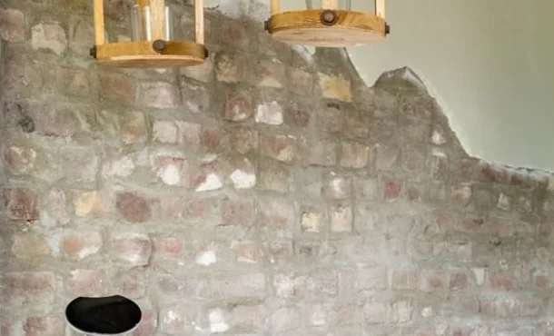 Oude bakstenen muur waar het pleisterwerk is weggehaald