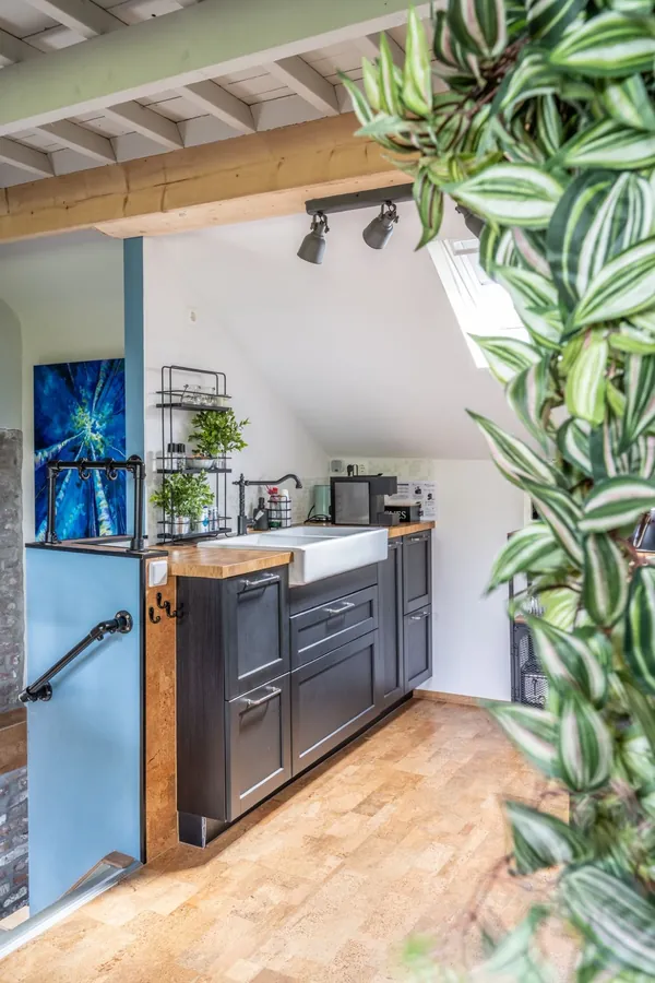 Keuken met blauwe wand, boerenspoelbak en planten